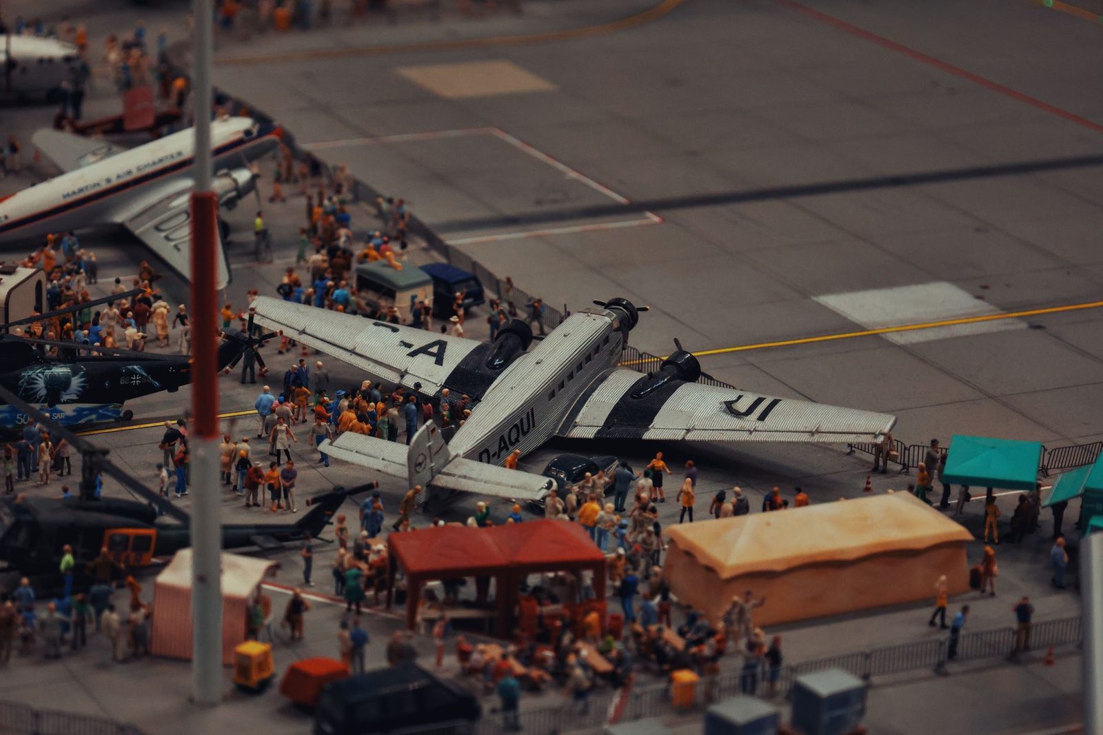A detailed miniature scene of airplanes and people at a crowded airport display.