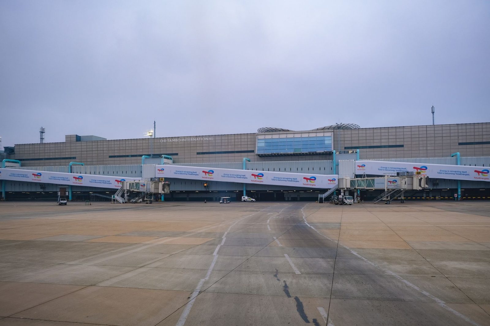 View of a modern airport terminal with jet bridges leading to the runway.