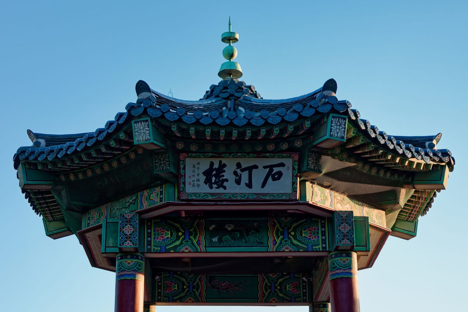 Close-up of a traditional Korean pavilion in Incheon, showcasing intricate architectural details under a clear blue sky.