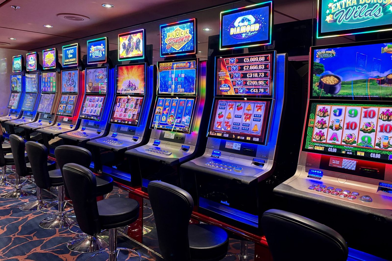 Bright casino slot machines with colorful displays and no people present.