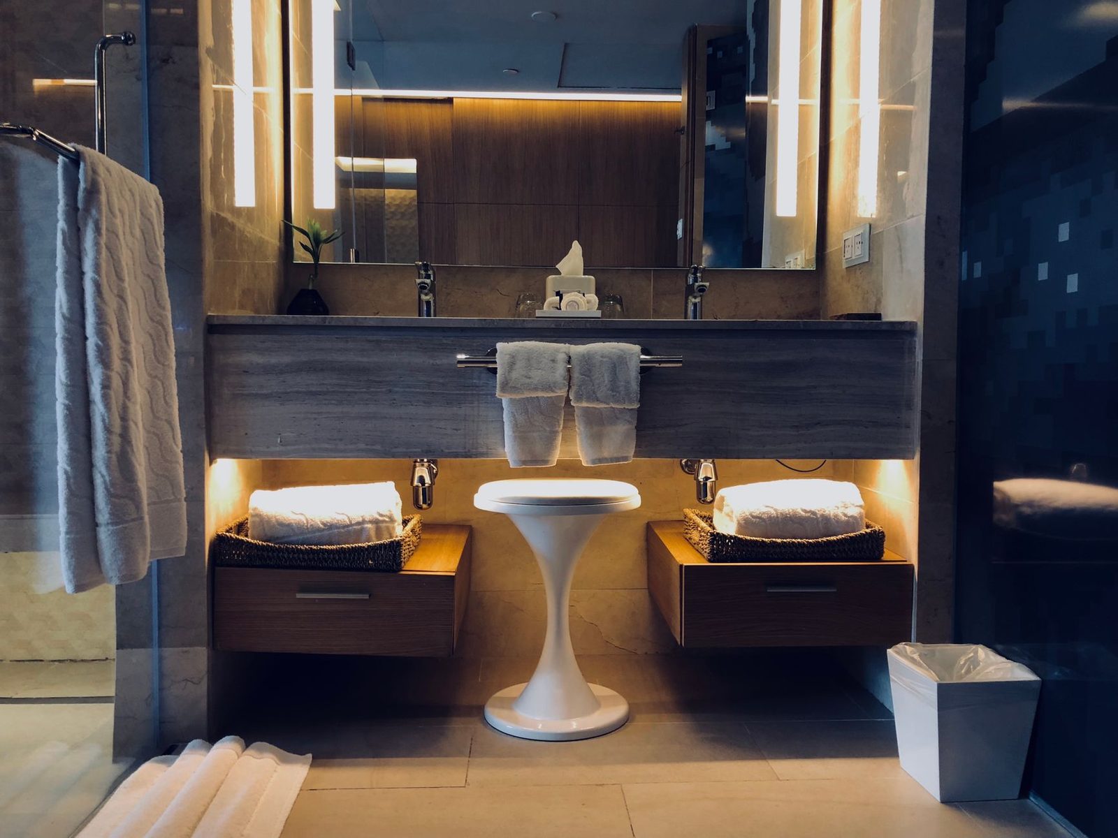 Stylish modern bathroom with illuminated vanity, mirrors, and cozy atmosphere.
