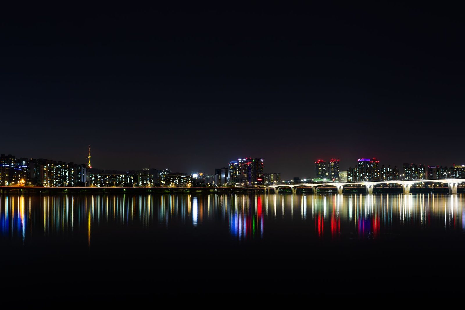 Stunning night view of Seoul's illuminated skyline reflected over the Han River.