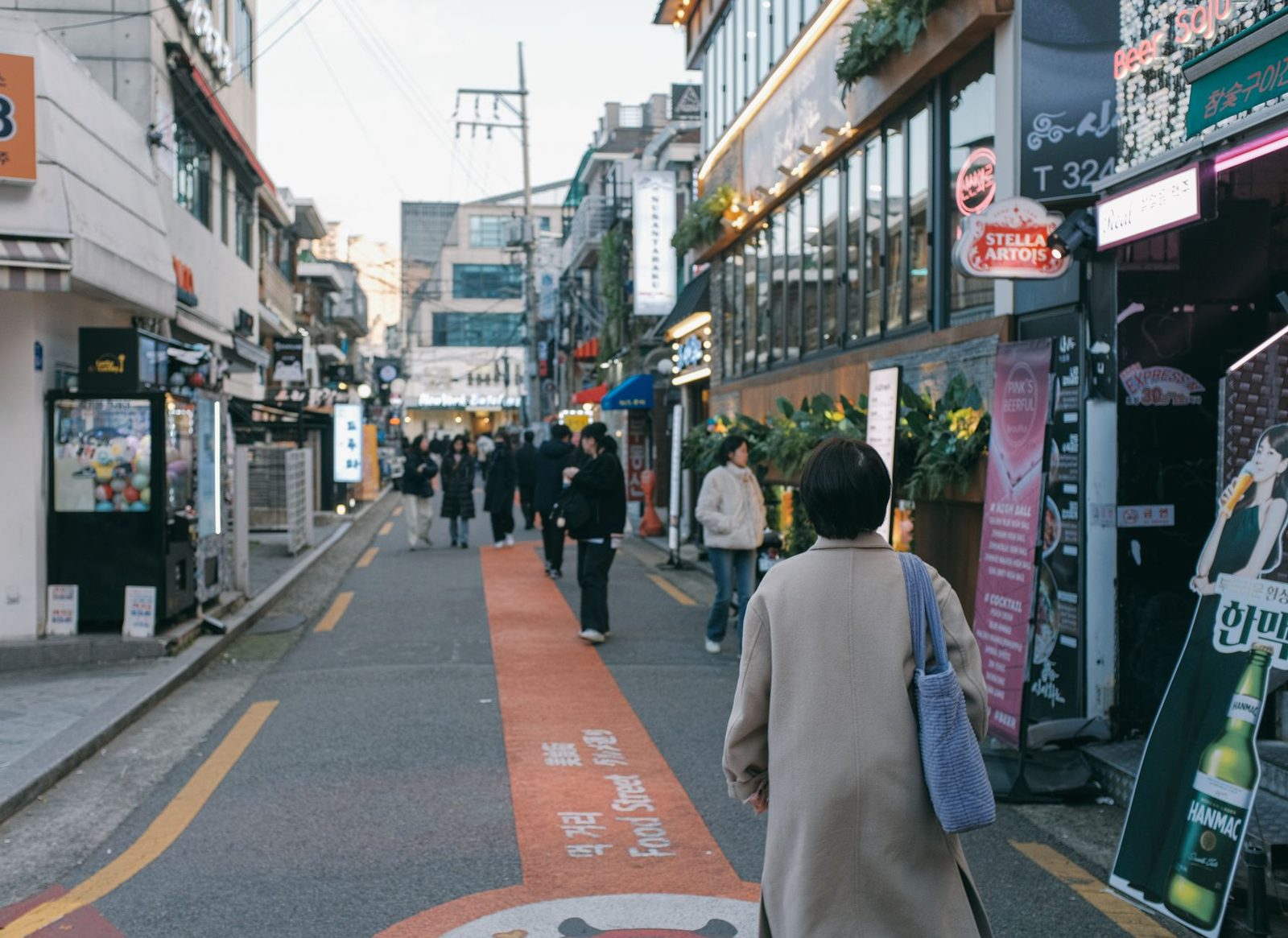 Crowded street in Seoul, bustling with pedestrians and modern shops, showcasing urban life.