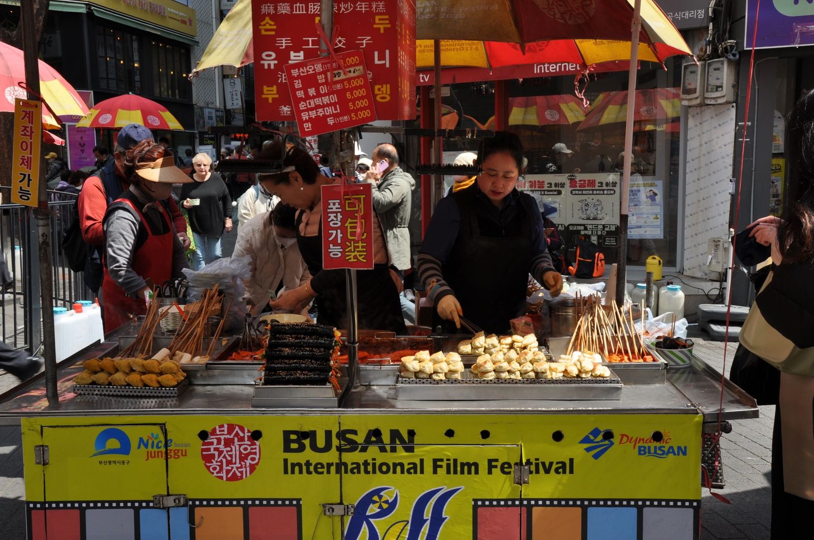 Vibrant street food stall at Busan International Film Festival serving skewers.