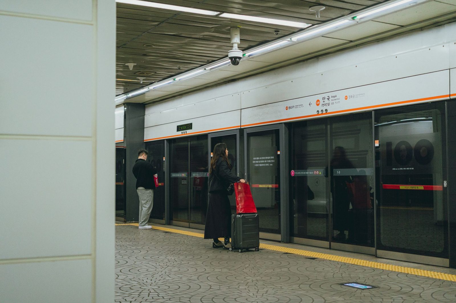Travelers await the subway in Seoul's metro during springtime, capturing urban life.