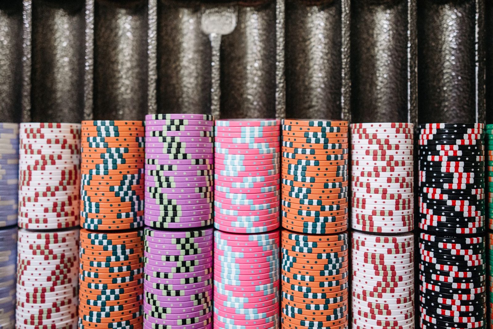 A close-up of colorful casino chips neatly stacked in rows, symbolizing the gambling experience.