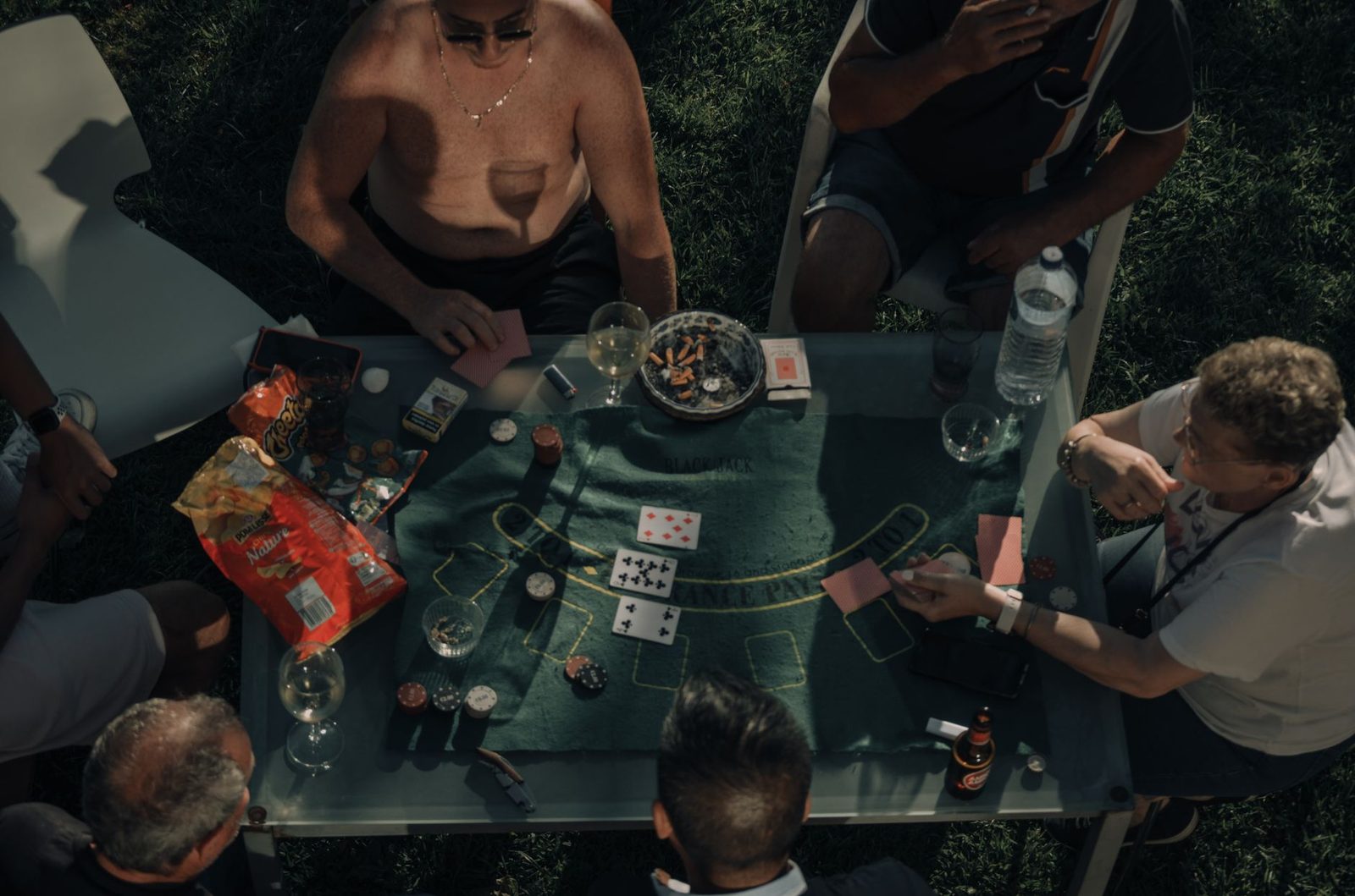A group of people playing cards and enjoying a casual outdoor game setting.