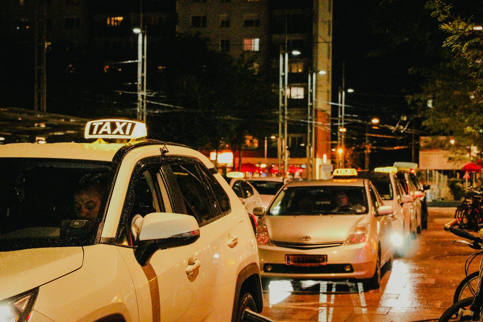 Taxis lined up under streetlights in Salzburg, Austria, captured at night.
