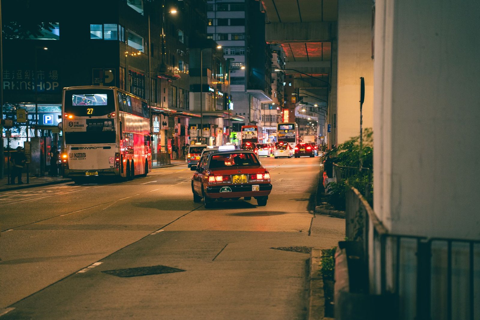 Vibrant city scene with buses and cars on a busy street in Hong Kong at night.