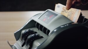両替所で紙幣を数える機械と手元