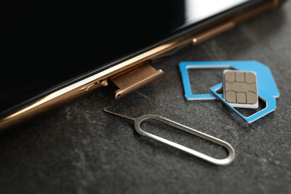 スマートフォンのSIMトレイと取り出しピン、SIMカード